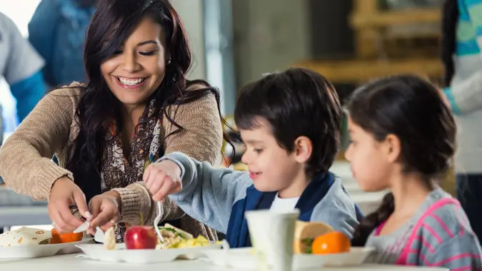 Mother and children eating meal in food bank soup kitchen stock photo