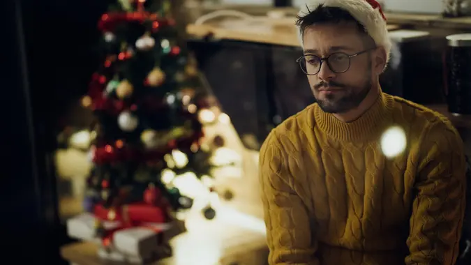 Young sad man spending Christmas Eve alone at home. stock photo
