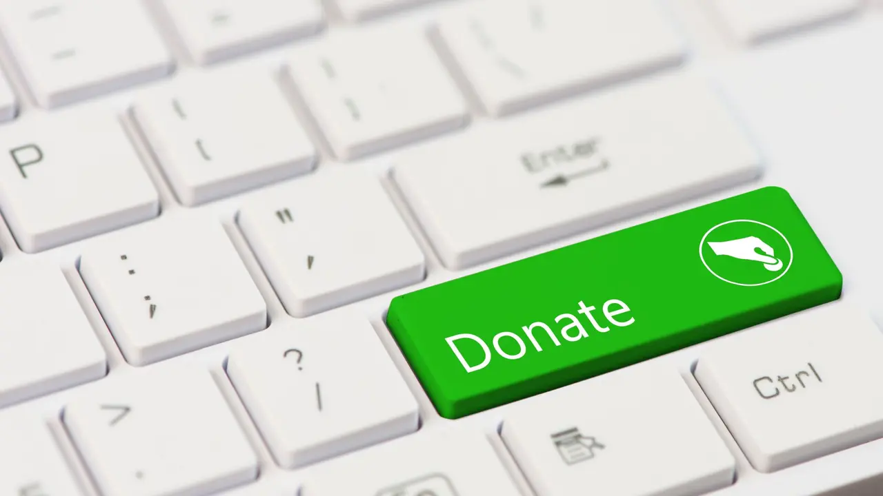 green key with text Donate on white laptop keyboard.