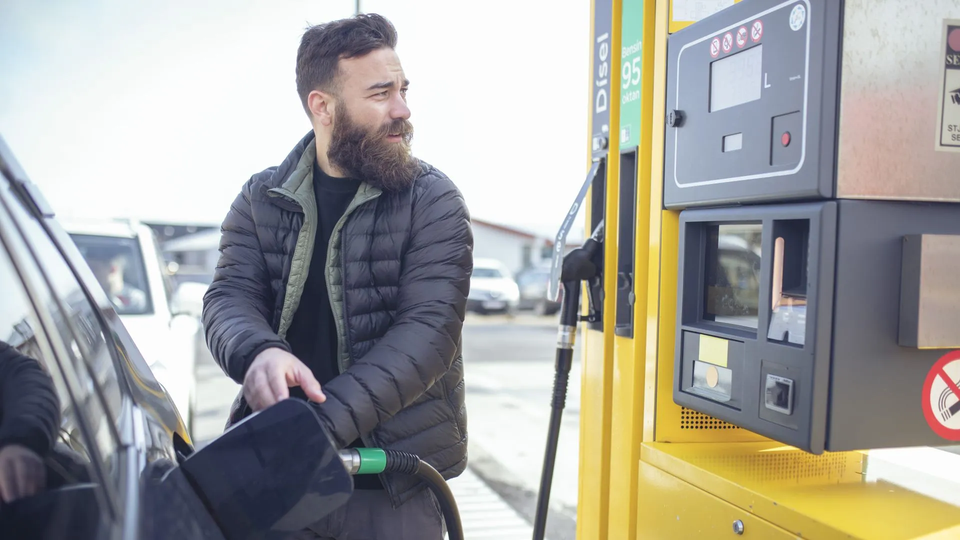 Before leaving and traveling by car, the man fills his tank with fuel.