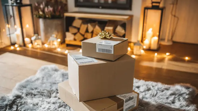 Cozy living room winter interior with fireplace, presents ordered online and delivered wait in front of fireplace.