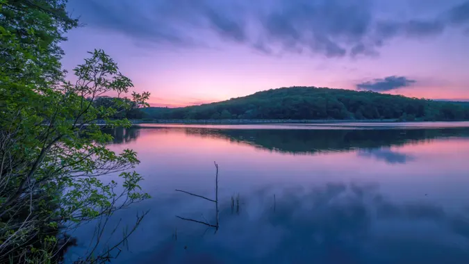 Beautiful sunset over Harriman park upstate New York featuring sky reflection and mountain on the background.