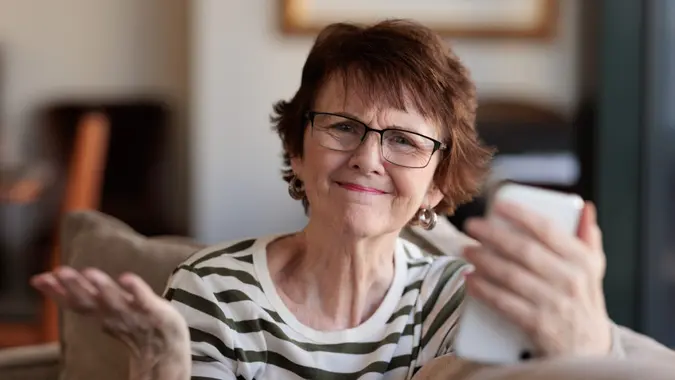 Senior woman with phone looking frustrated.