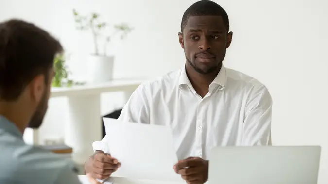 African-american hr manager looking doubtful skeptical about hiring incompetent candidate stock photo