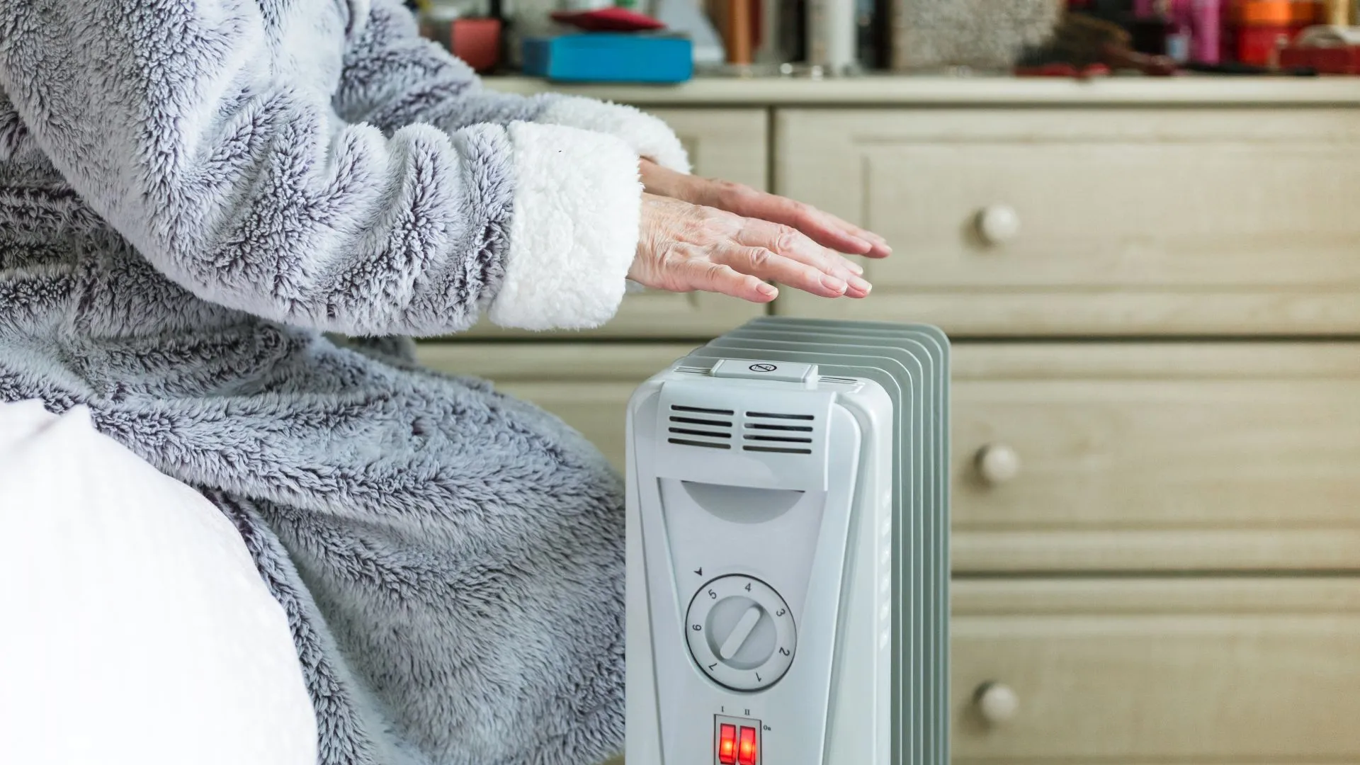 一个退休的高级的女人在她70年代坐在家里面冬天寒冷的房子。