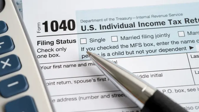Tax Return form 1040 with USA America flag and dollar banknote, U.