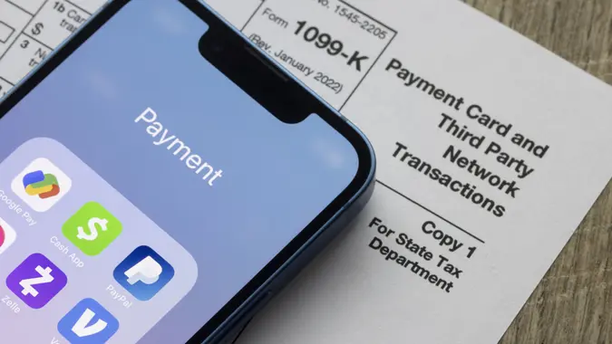 Portland, OR, USA - Jan 5, 2022: Payment apps like PayPal and Venmo are seen on an iPhone on top of Form 1099-k.
