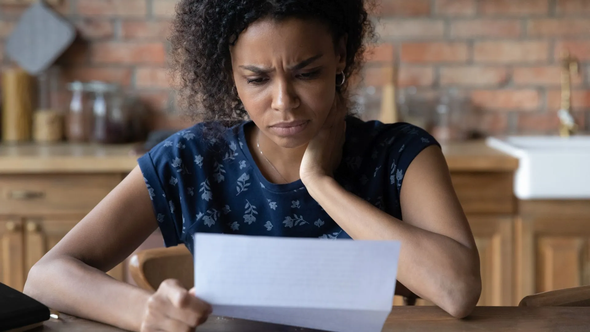 特写不快乐的非裔美国年轻女性阅读信件，文件，沮丧的女商人或学生收到坏消息，意外债务或解雇通知，财务问题。