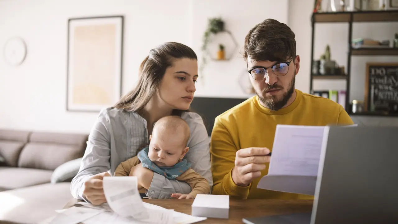 Young family with baby worried about family budget and high taxes and bills.