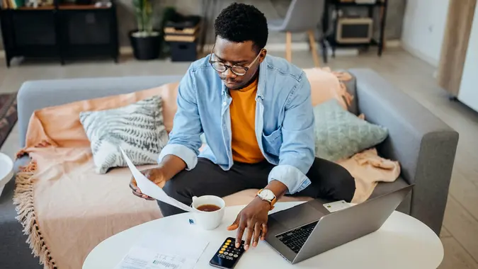 Young handsome serious man calculating his bill stock photo