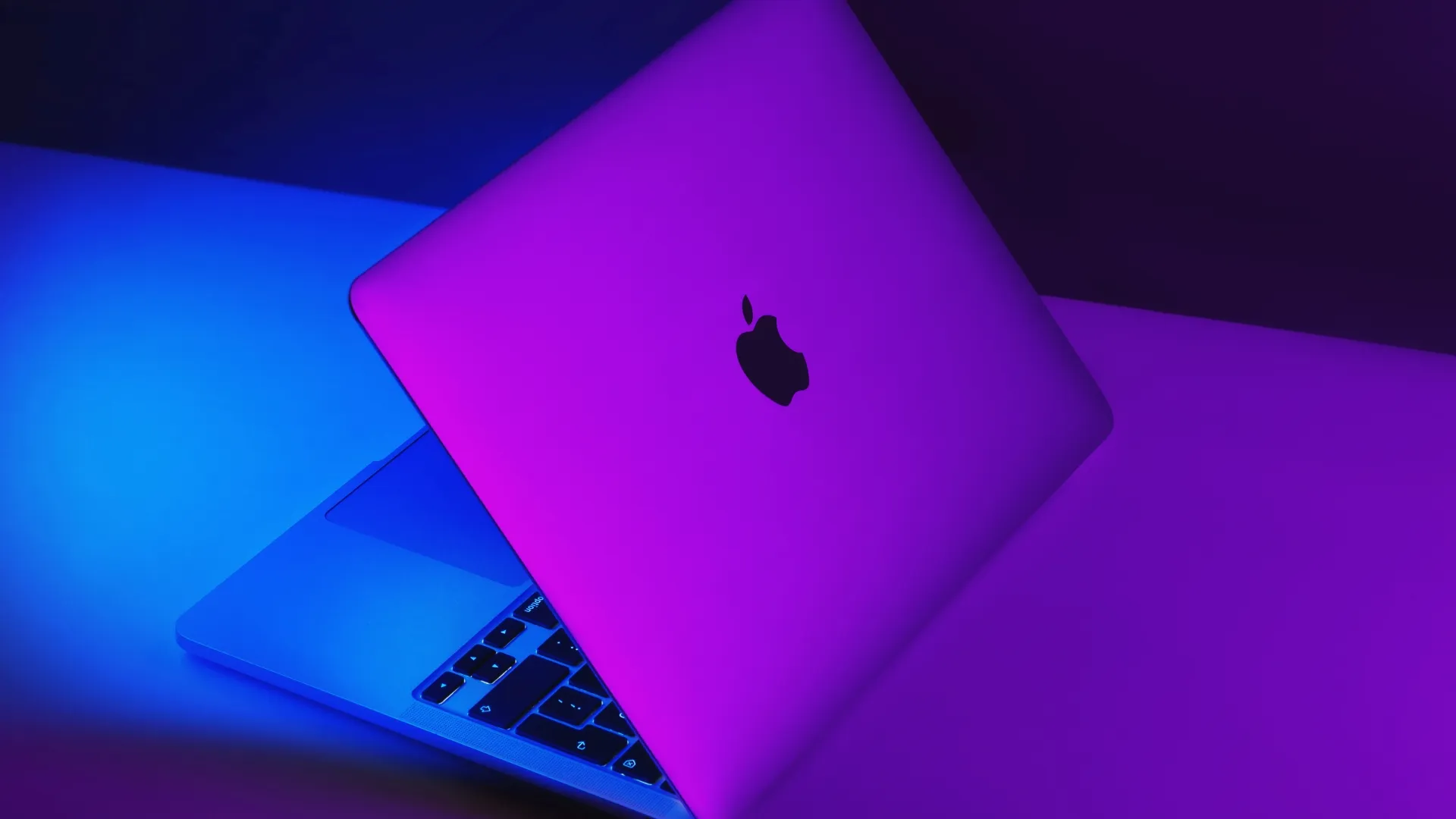 Izmir, Turkey - January 10, 2022: Half opened Apple Brand M1 Model Macbook pro laptop computer with purple and blue colored lights.