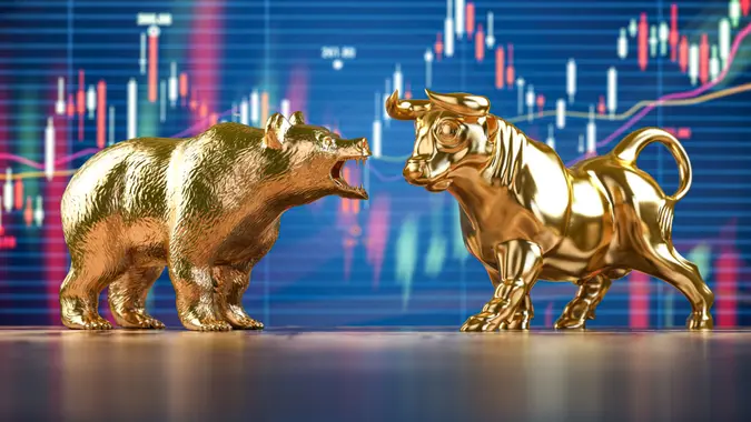 Golden bull and bear on stock data chart background.