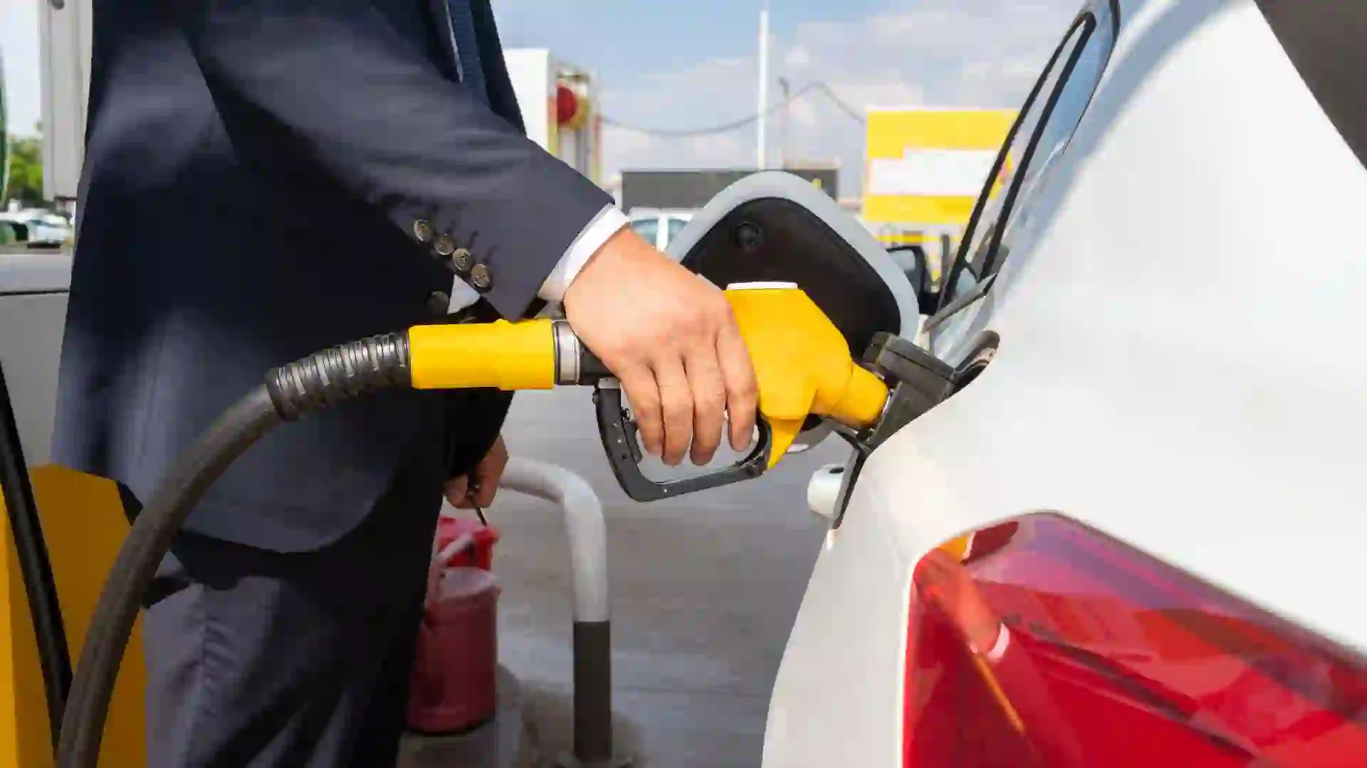 Hand Holding Fuel Pump And Refilling Car At The Gas Station.