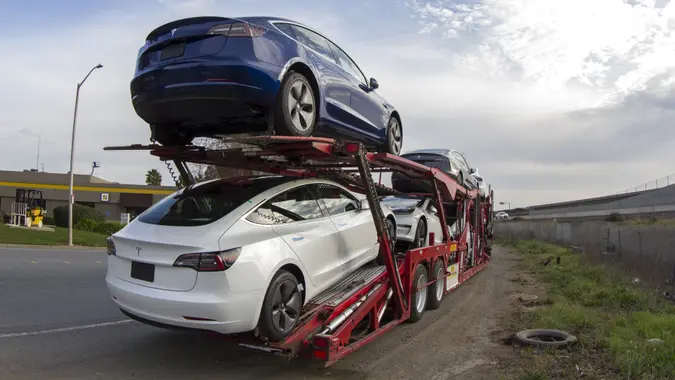 Fremont, CA, USA - Feb 28, 2020: A car carrier trailer loaded with new Telsa electric vehicles parked by the roadside near Tesla Factory in Fremont, California.