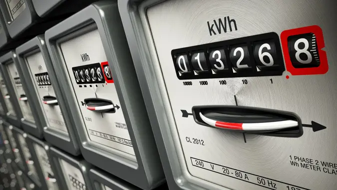Electric meters in a row standing on the wall.