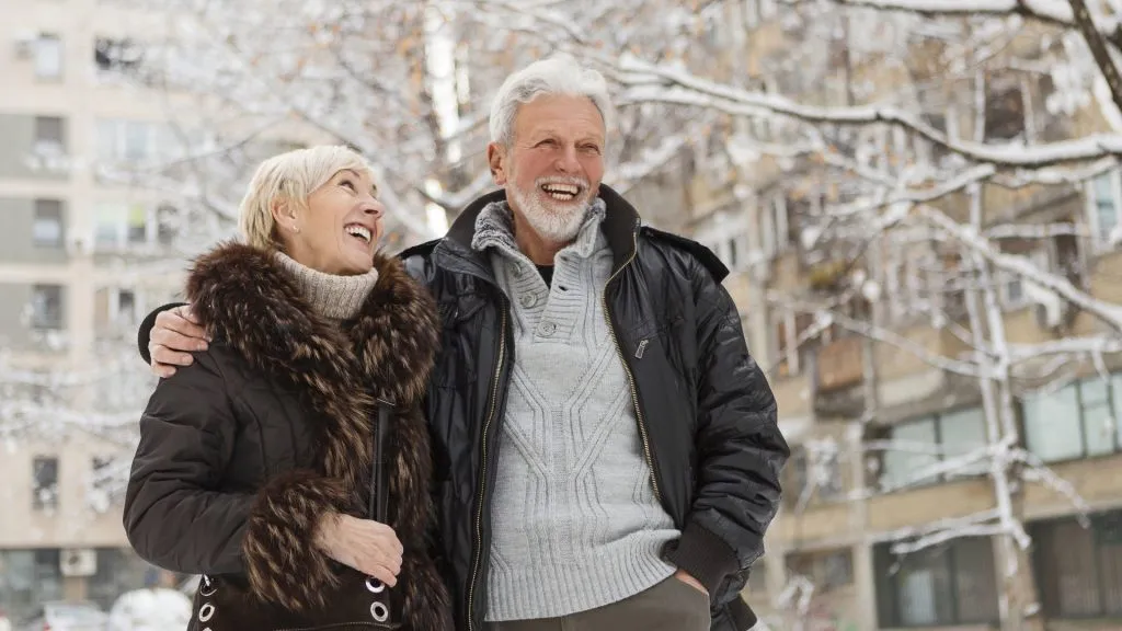 Happy senior couple walking outdoors on a winter day.