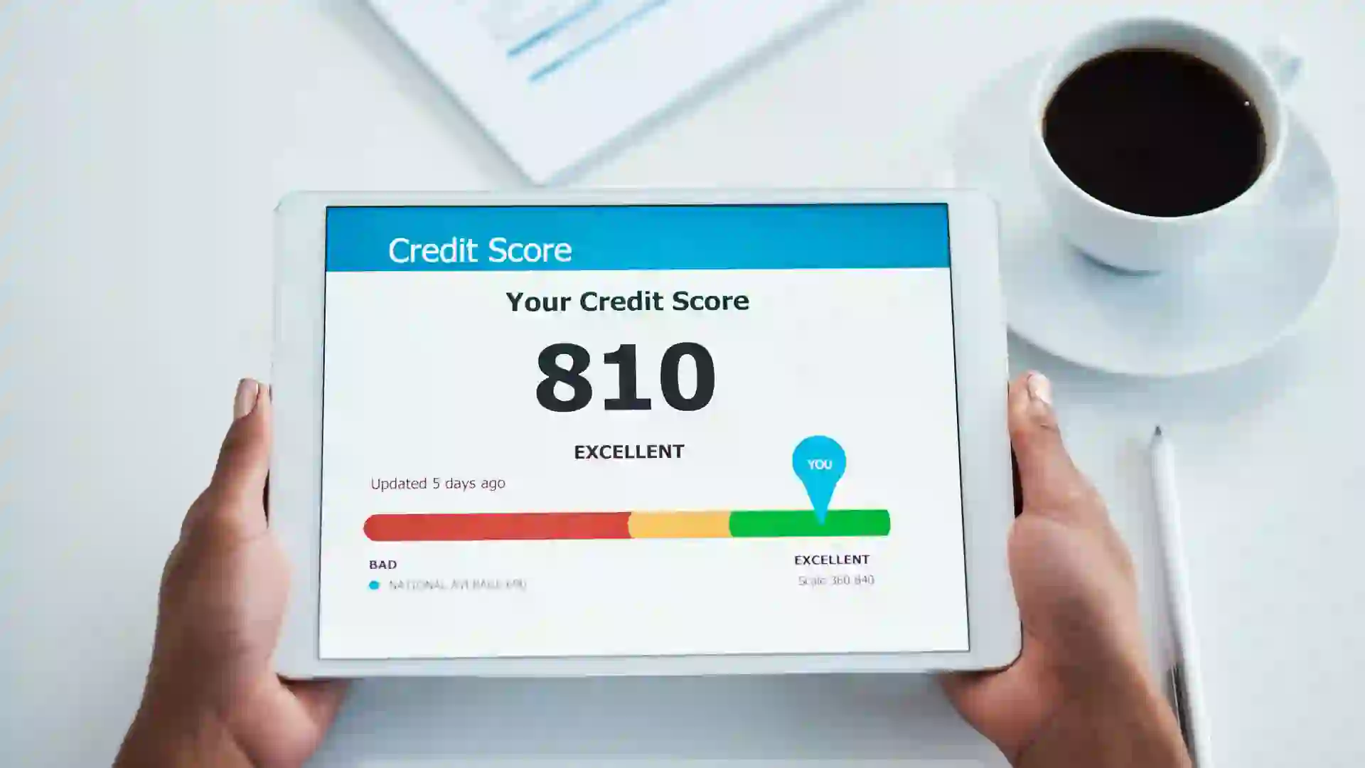 A businesswoman holding a digital tablet showing her credit score.