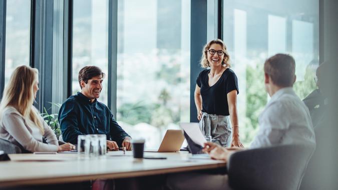 Office colleagues having casual discussion during meeting in conference room.