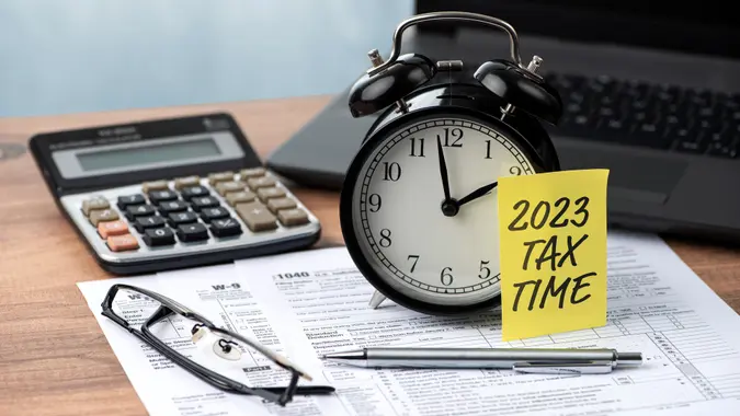 2021 TAX TIME note is on the alarm clock.