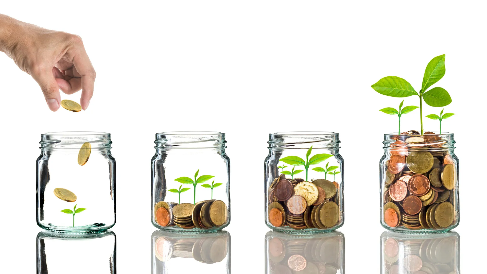 Hand putting gold coins into clear bottle on white background,Business investment growth concept.
