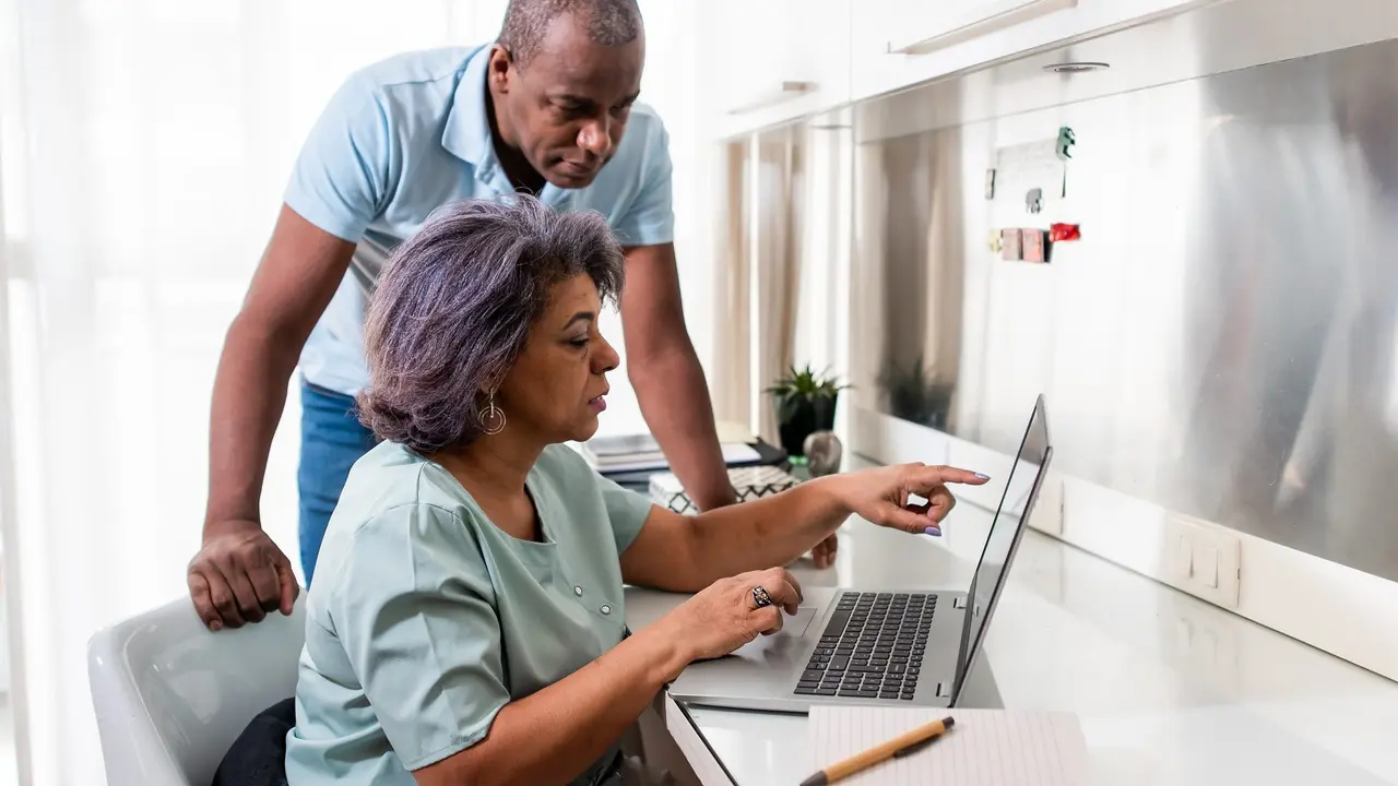 Mature couple using laptop at home. stock photo
