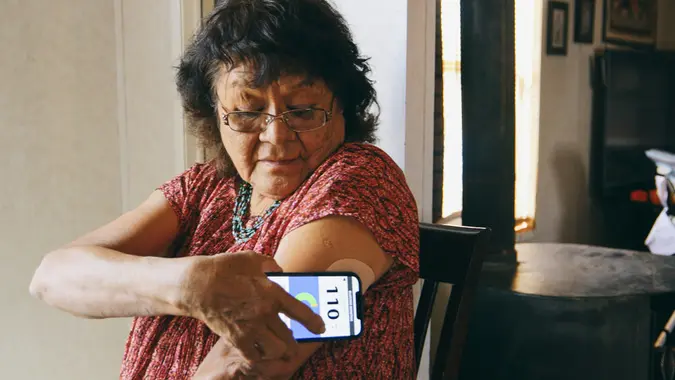 Senior Woman Checking Blood Glucose Level on an App stock photo