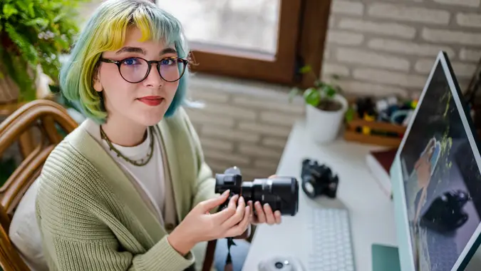 Millennial photographer working on her photos at home office.