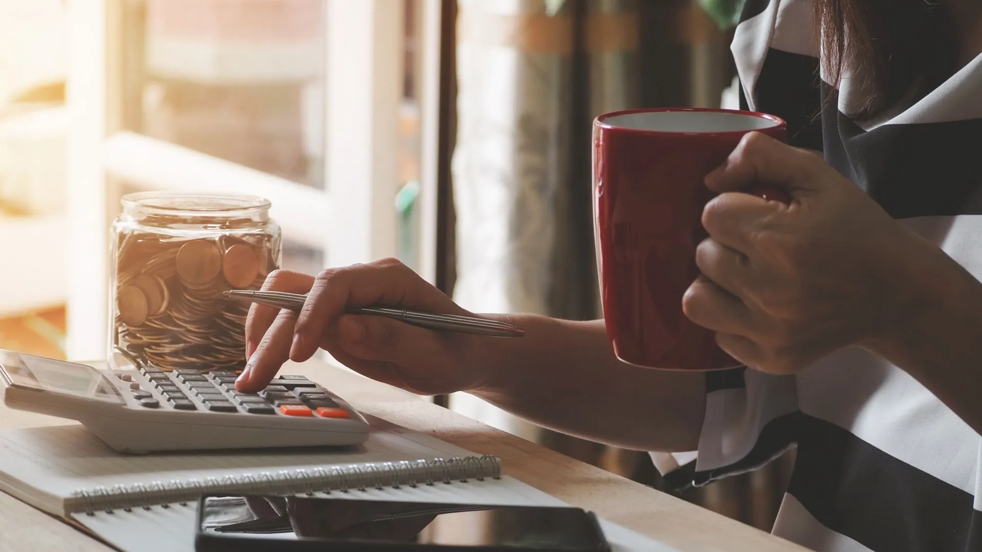 woman using calculator calculating monthly home expenses, taxes, bank account balance and credit card bills payment, concept saving money.