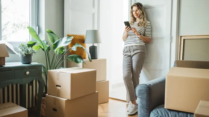 Mature woman moves in to new home, unpacking boxes and enjoying in her new home.