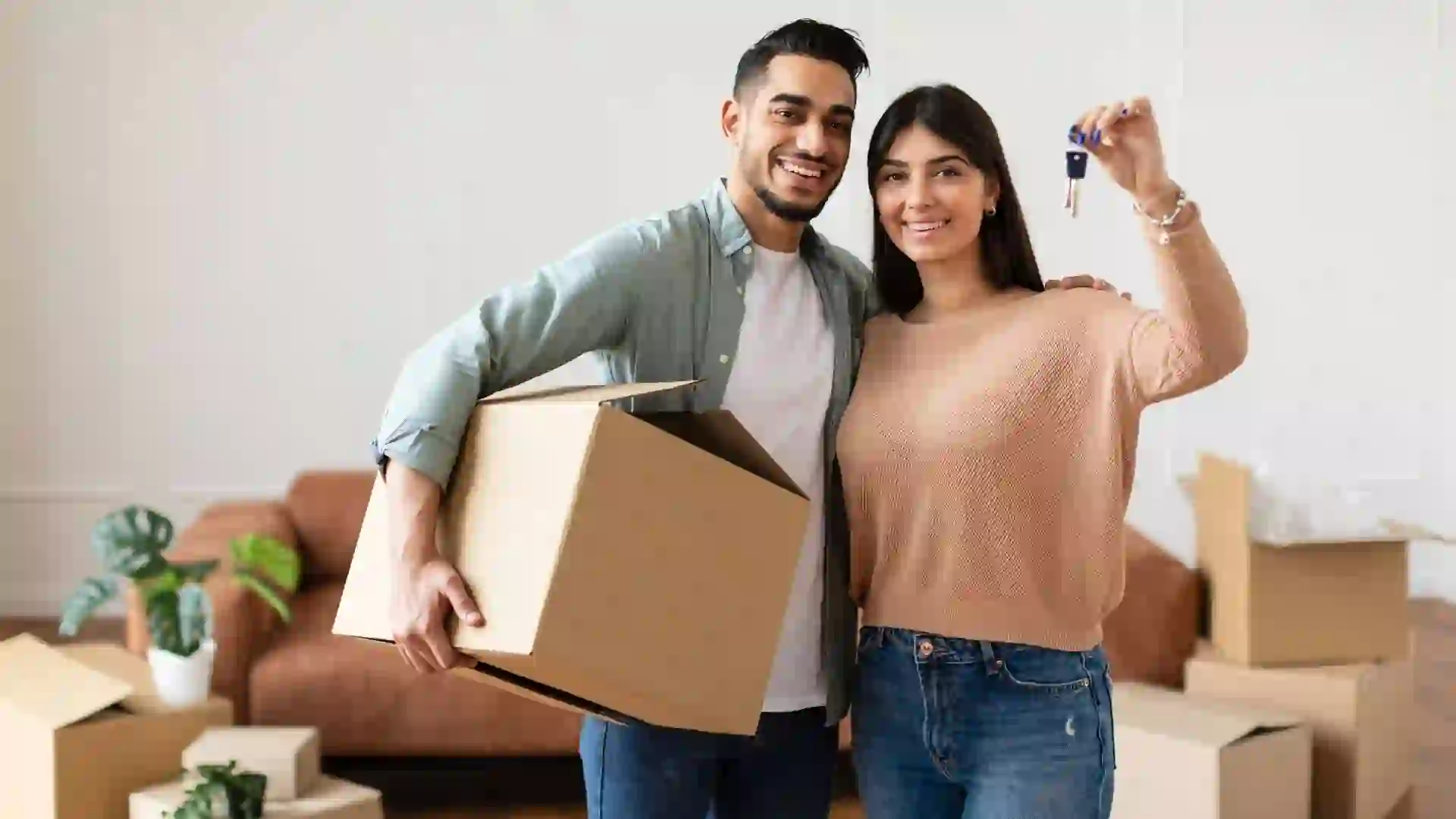Couple holding keys to house