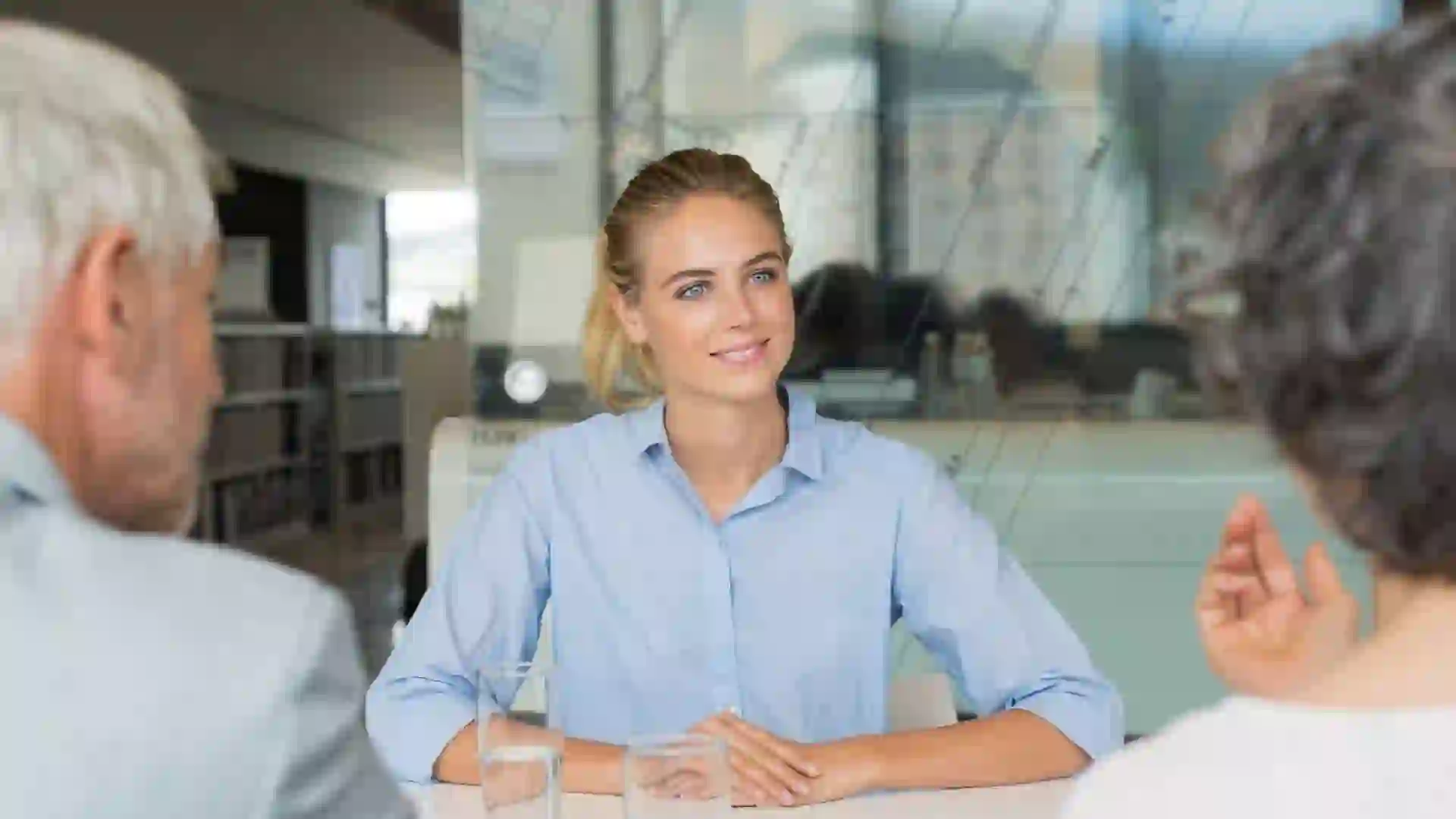 Portrait of beautiful young woman sitting in front of manager and senior leader during a job interview.