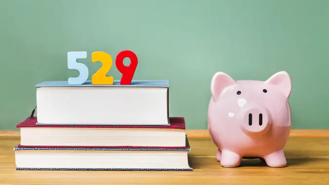 529 college savings plan theme with textbooks and piggy bank and green chalkboard background.