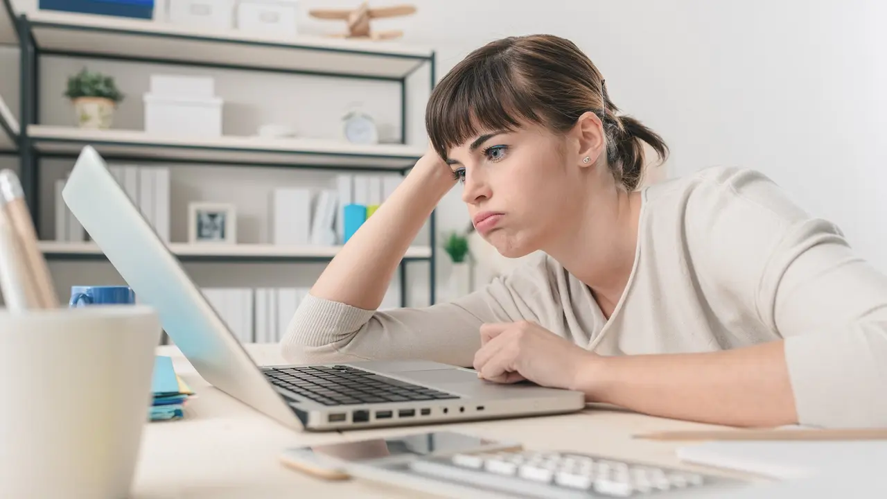Disappointed woman working with a laptop stock photo
