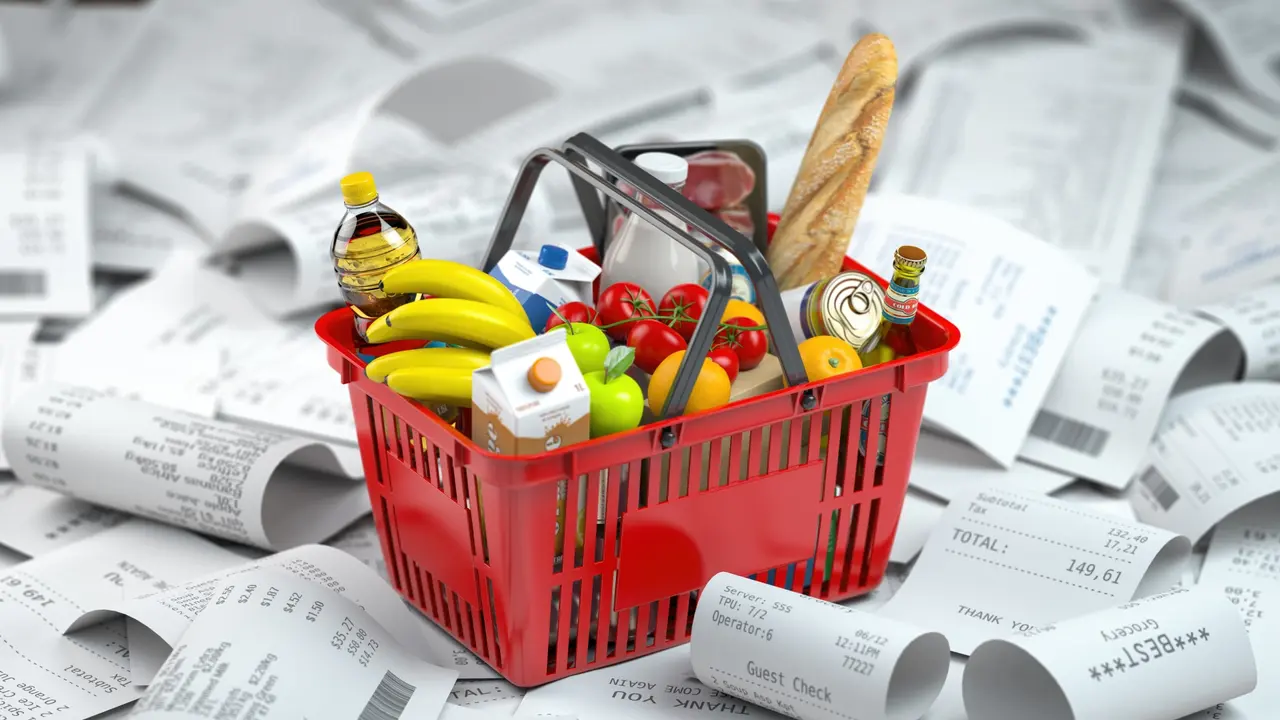 Shopping basket with foods on the pile of receipt.