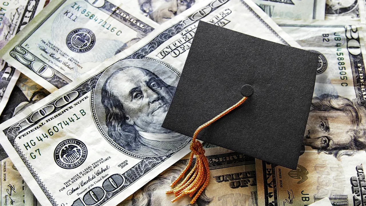 Miniature graduation cap on hundred dollar bills.