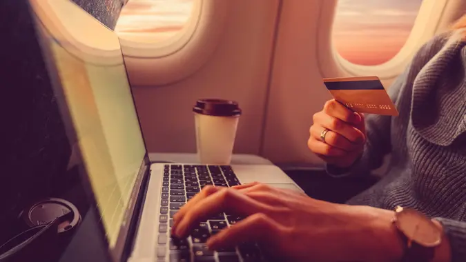 Passenger shopping online with credit card in the airplane stock photo