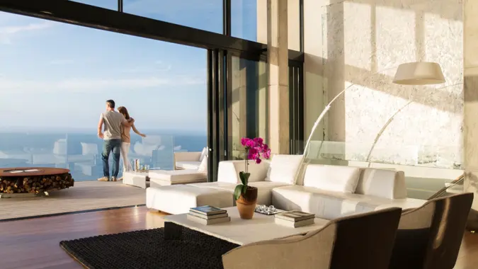 35-39 years, 40-44 years, affection, balcony, blue sky, bonding, cape town, casual clothing, caucasian, color image, copy space, couple, day, deck, domestic life, doorway, escapism, freedom, full length, getting away from it all, glass wall, heterosexual couple, horizontal, house, indoors, leisure, living room, love, luxury, man, mature adult, mature men, mid adult, mid adult women, modern, nature, ocean, outdoor living, patio, people, photography, railing, rear view, relaxation, romance, seascape, showcase interior, sliding door, south africa, standing, three quarter length, togetherness, togethernesscaucasian, travel, two people, unwinding, vacations, water, wealth, weekend activities, white, window, woman