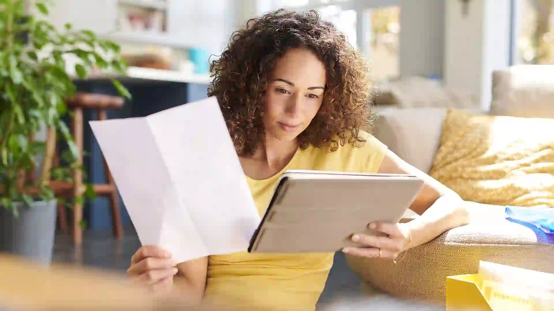 Stock photo shows woman reviewing her finances, budget, paperwork or other documentation to make decisions