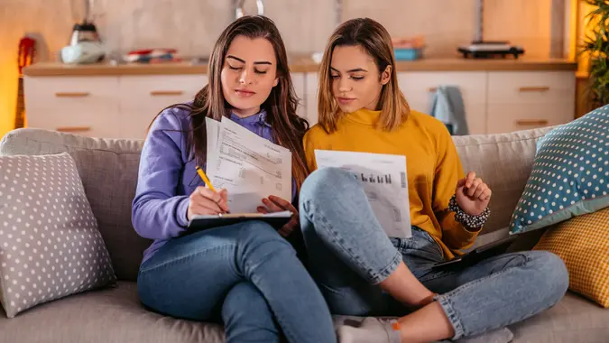 Young lesbian couple calculate home financial bill budget stock photo