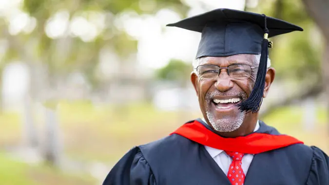 A senior black man graduates with his master's degree.