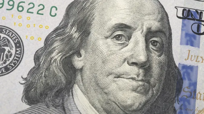 Closeup of a hundred dollars bill showing Benjamin Franklin.
