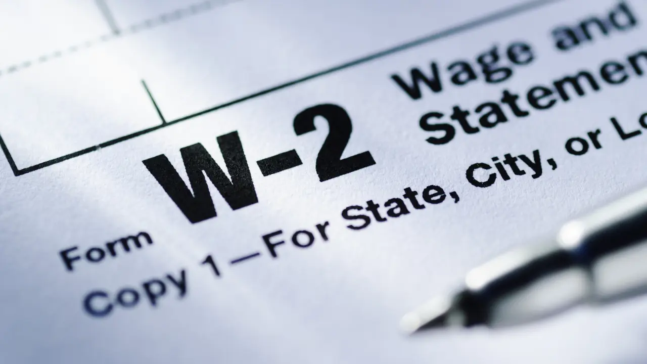 Pen on a Form W-2 Wage and Tax Statement for the US Treasury to be submitted by the employer in close up in a conceptual financial image.