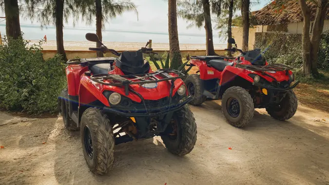 Red ATV on the background of a tropical landscape.