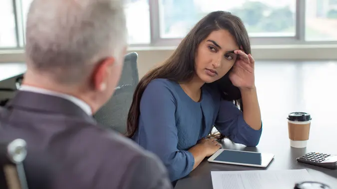 Business leader instructing focused Indian female assistant.