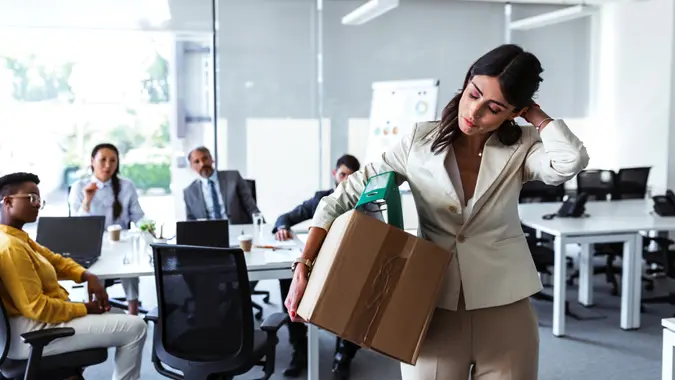 Stress of business woman packing brown cardboard box her belonging after resign and signing cancellation contract letter, Change of job unemployment or resignation concept.