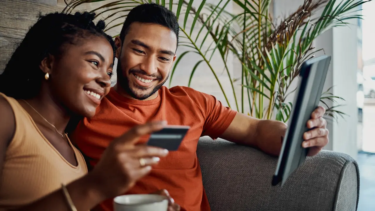 Shot of a young couple sitting together in the living room and using a digital tablet for online shopping stock photo