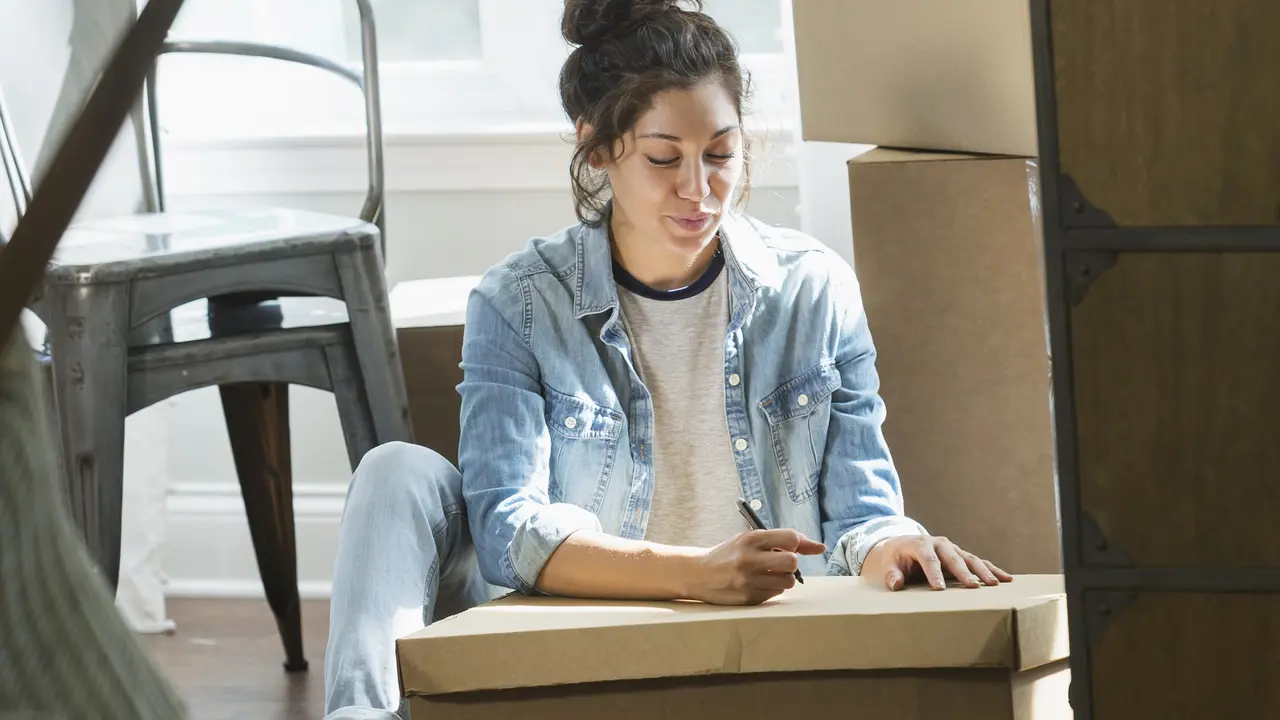 Young mixed race woman moving, writing checklist stock photo
