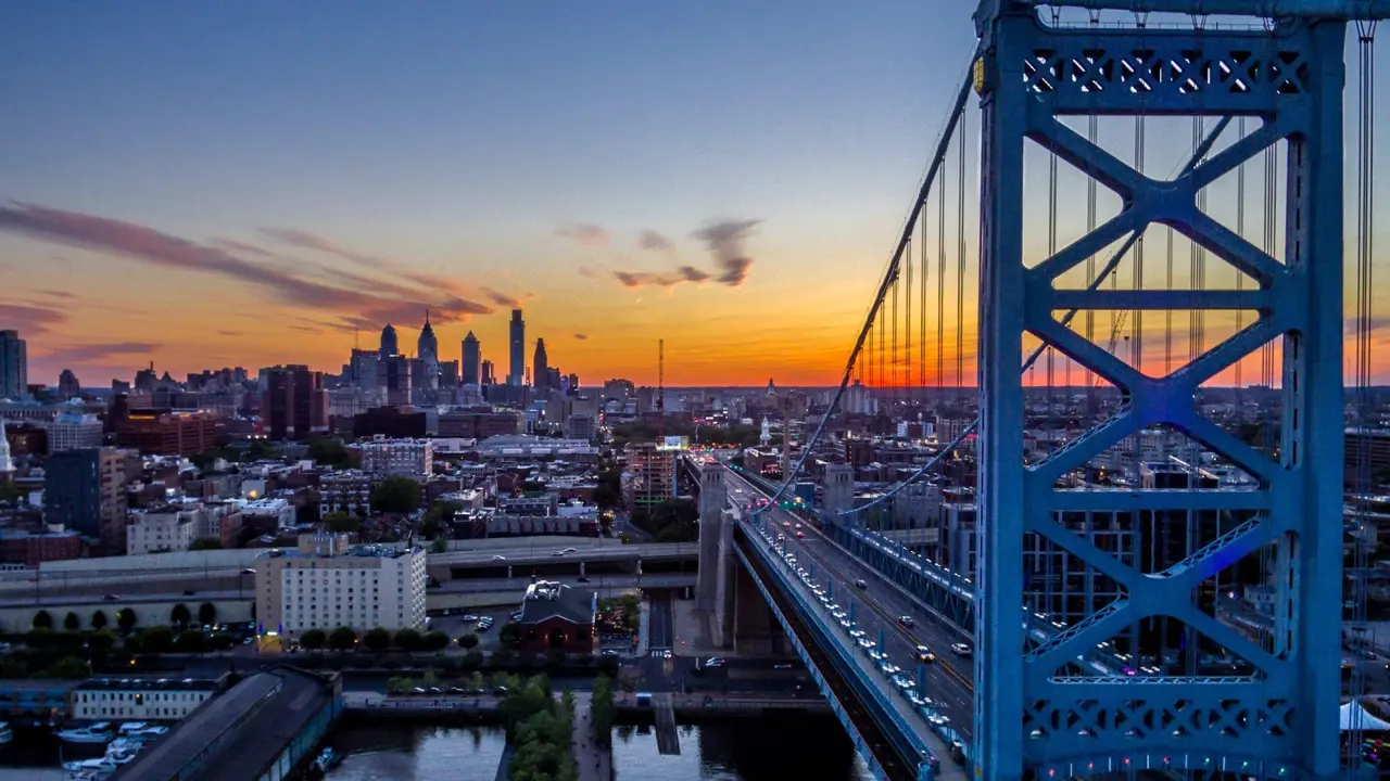 Mid-air aerial view of sunset over Philadelphia's skyline and Race Street pier at the bottom.