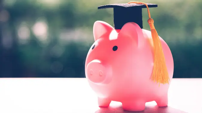 Save money coins in piggy bank and graduation cap, Business finance education concept. stock photo