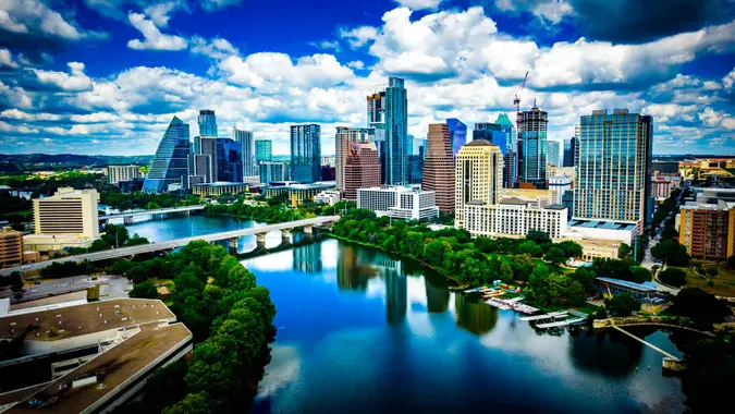 Aerial drone views perfect reflections of boue sky and puffy white summer clouds along austin texas skyline cityscape.
